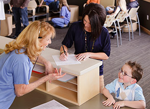 Team member talking to child and mother