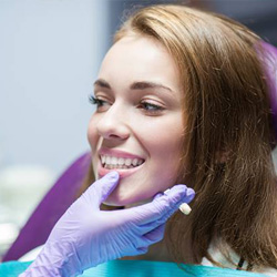 Dentist examining woman’s smile