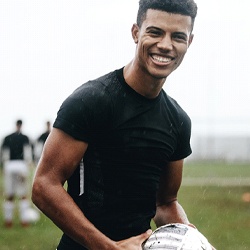 soccer player smiling holding ball