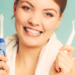 woman holding toothbrush and tongue scraper
