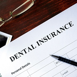 a dental insurance claim form with a pen on top of it