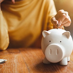 a person putting money in a piggy bank