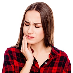 Young woman in pain holding cheek