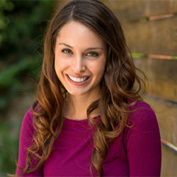 A woman smiling outside.