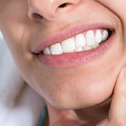 close up of person holding their jaw in pain