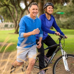 Older couple exercising in the park together