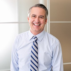 Man smiling in office wearing tie