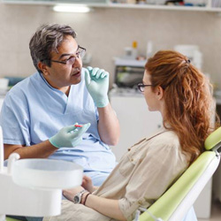 Dentist talking to female patient