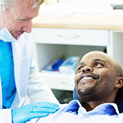 Man in dental chair smiling at dentist