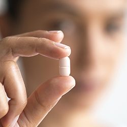 Hand holding a tablet pill