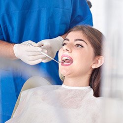 Young woman in dental chair receives examination