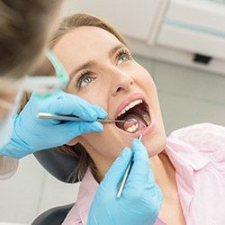 Woman in dental chair examined by dentist