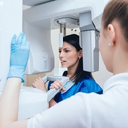 A dental employee setting up a cone beam scan for a patient.