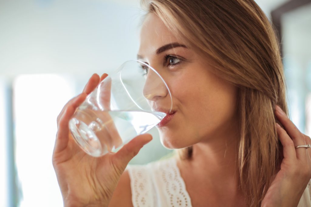 Woman drinking water on advice of a dentist in Sugar Land
