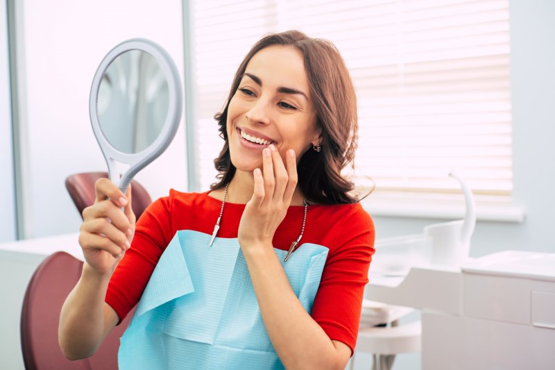 Woman smiling at reflection at dentist's office