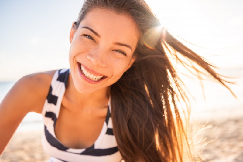 Woman smiling in the sun on the beach
